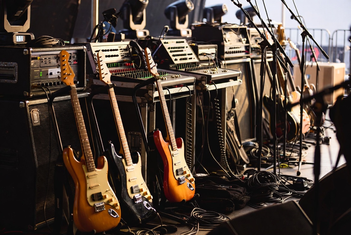 Backstage at a music festival with instruments and production equipment staged for performance illustrating the gear, rigging, and inland marine exposure tied to live music events