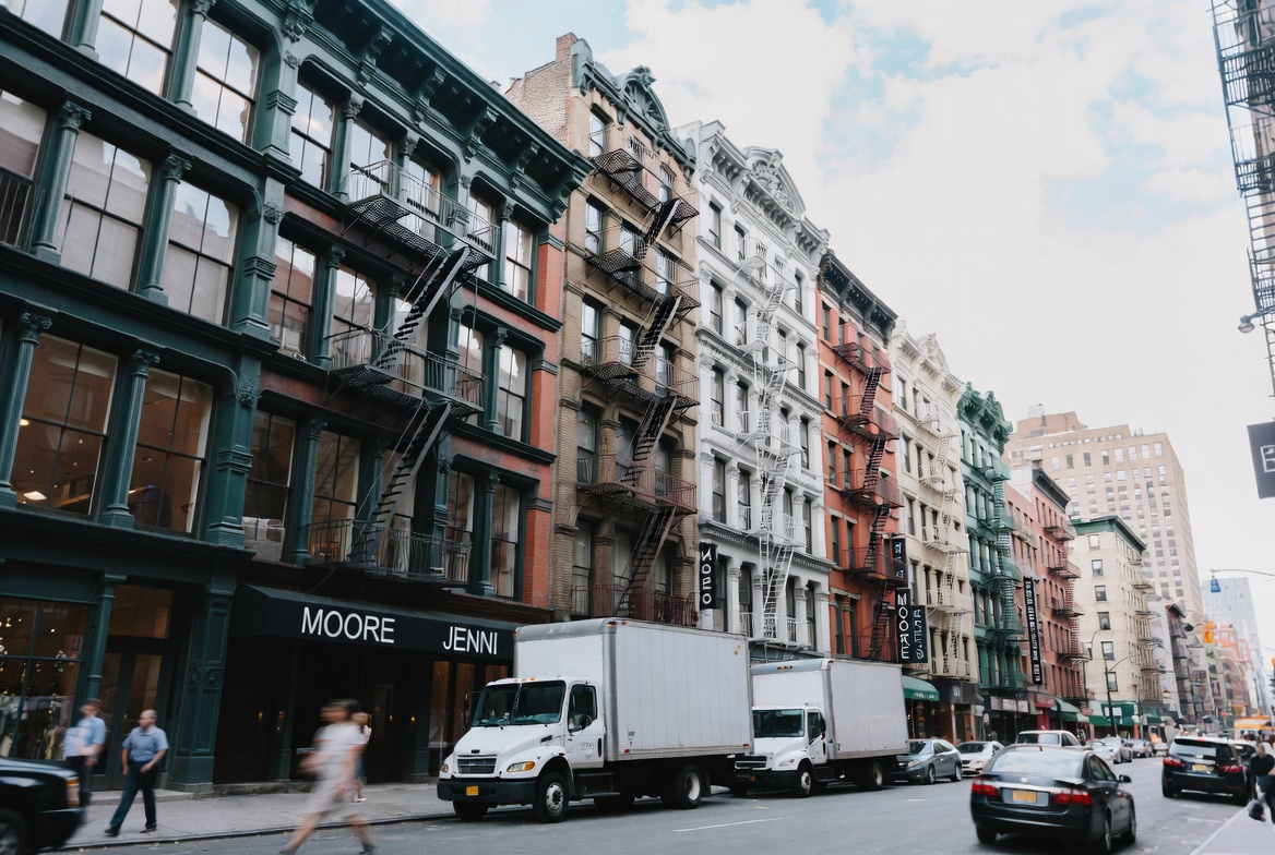 Bustling Garment District New York street scene with fashion showrooms and truck loading for Garment District business insurance
