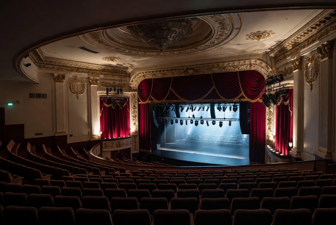 Elegant theater auditorium with stage curtains and tiered seating for performing arts theater insurance