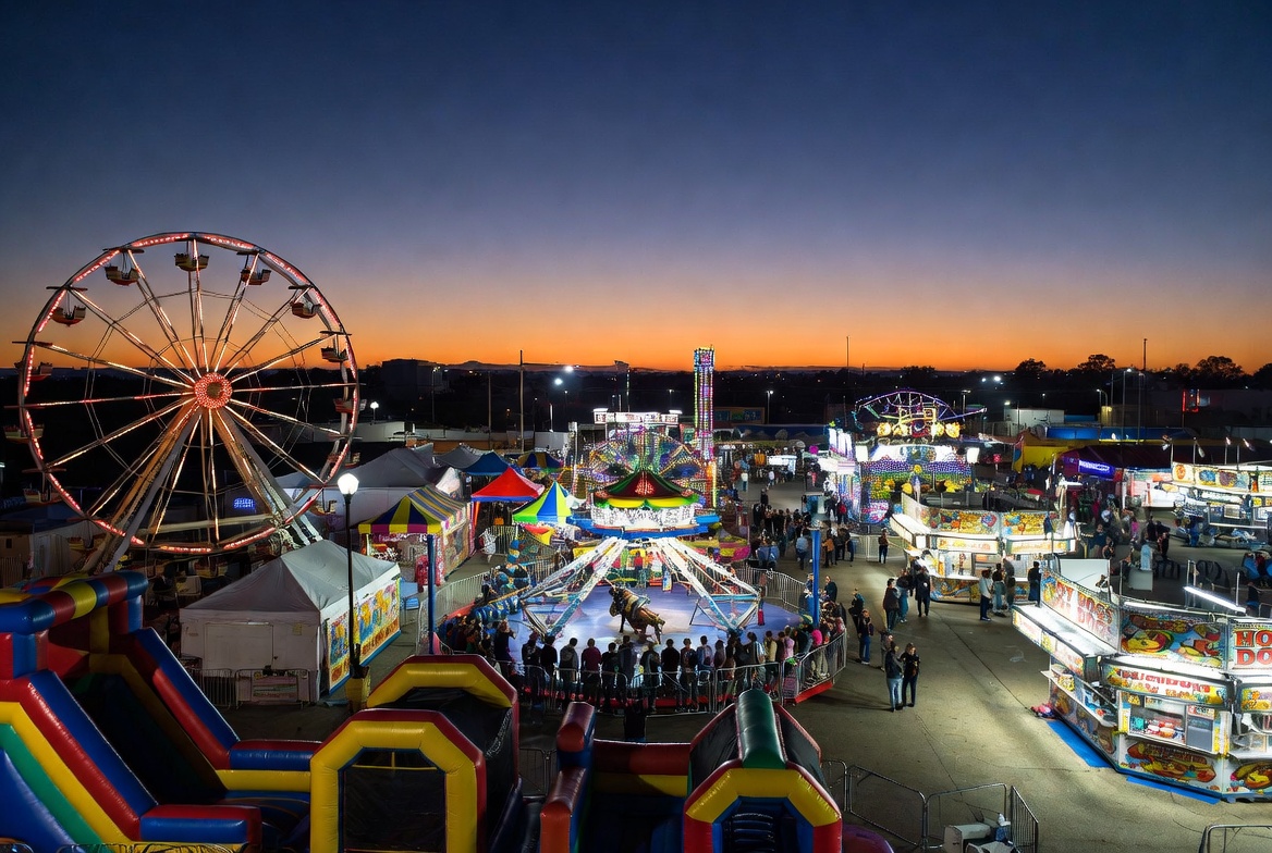 Full carnival midway with rides and inflatables for amusement entertainment device insurance