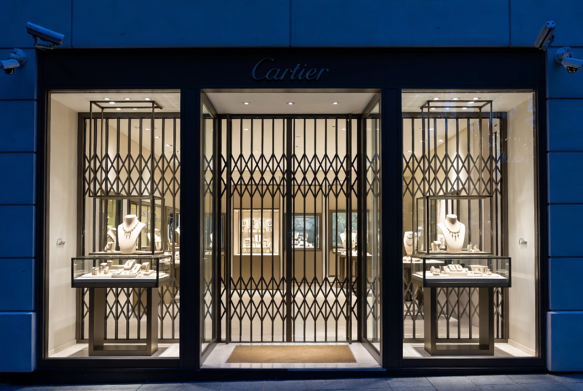 High-security fine jewelry storefront exterior at night with reinforced glass and cameras