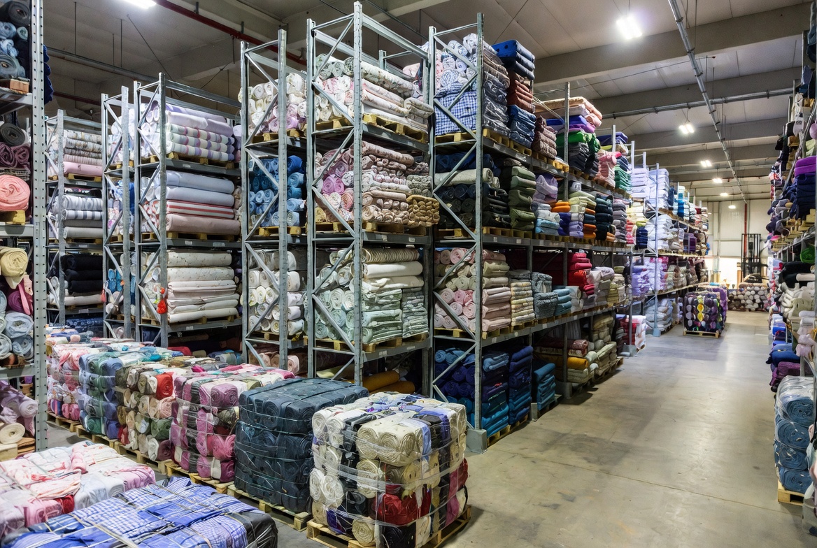 Large textile importer warehouse filled with colorful fabric rolls and bales