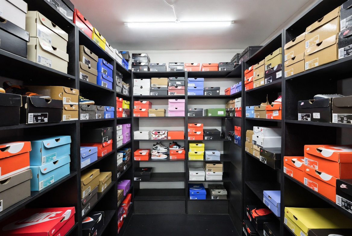 Luxury sneaker store back room with authentication station and organized storage vault housing high value sneaker boxes