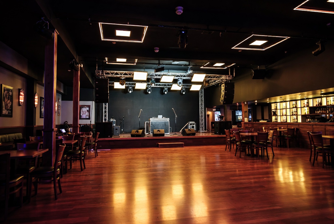 Nightclub tavern stage and dance floor setup with lighting and sound equipment