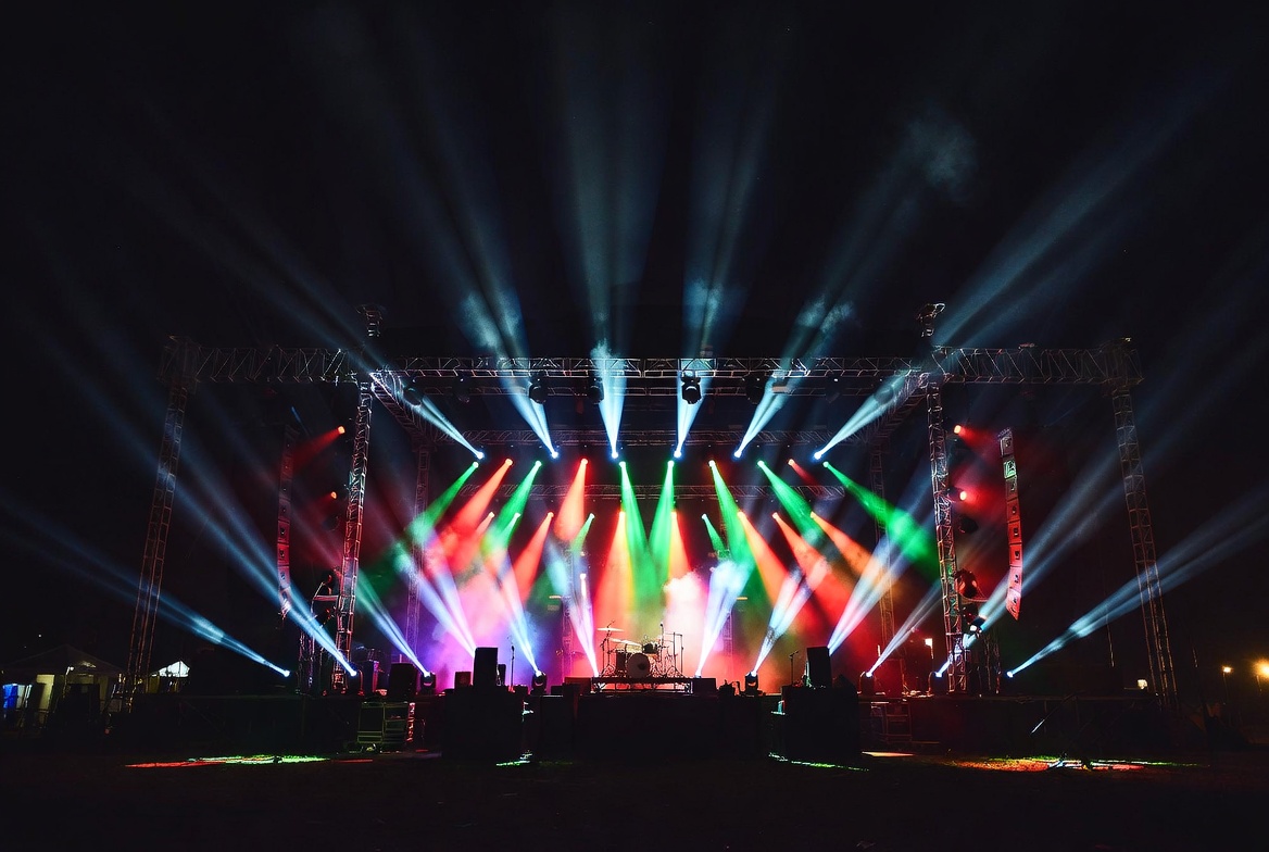 Nighttime concert venue stage with vibrant performance lighting and stage equipment representing an active live music production