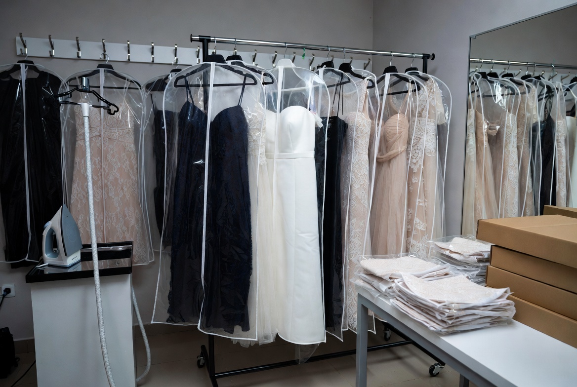 Professional dress rental packaging and transport preparation station with garment bags for wardrobe insurance