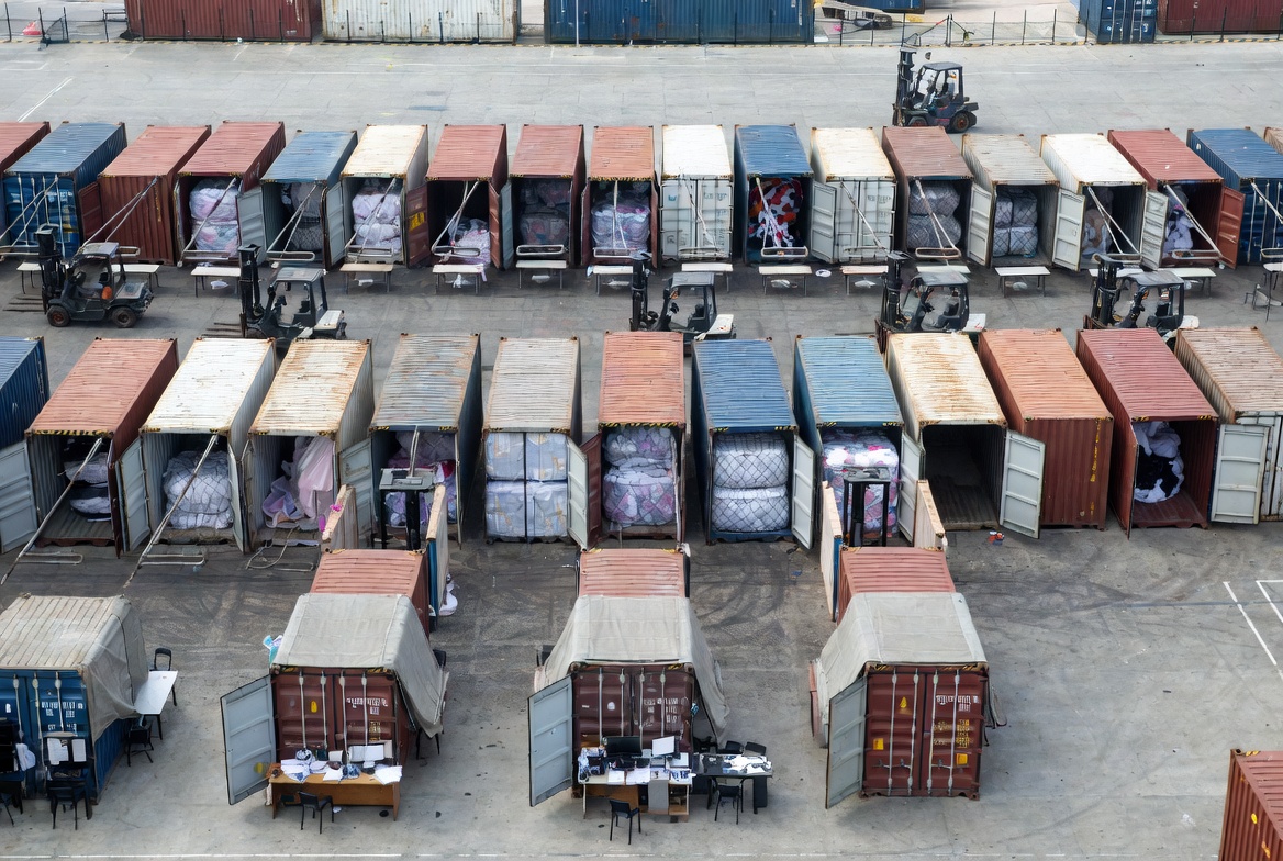 Textile importer customs clearance area with shipping containers and inspection station