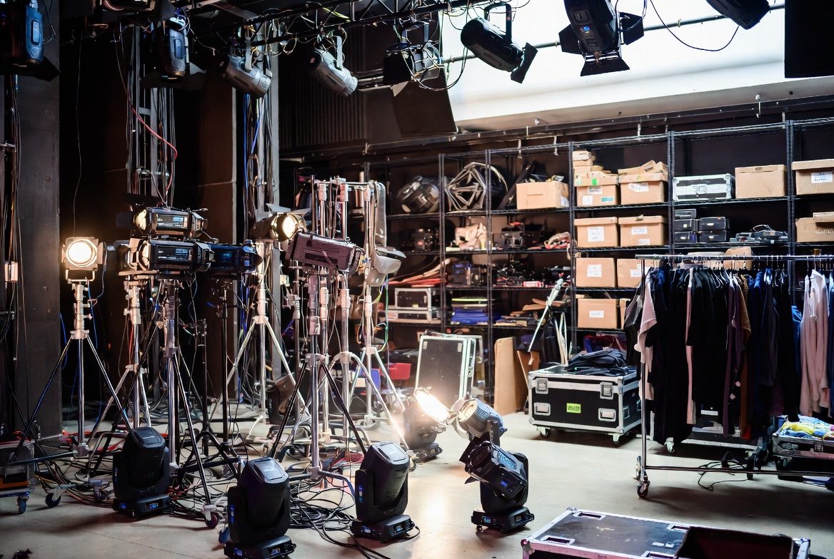 Theater backstage area with lighting rigs props and costume racks for performing arts insurance