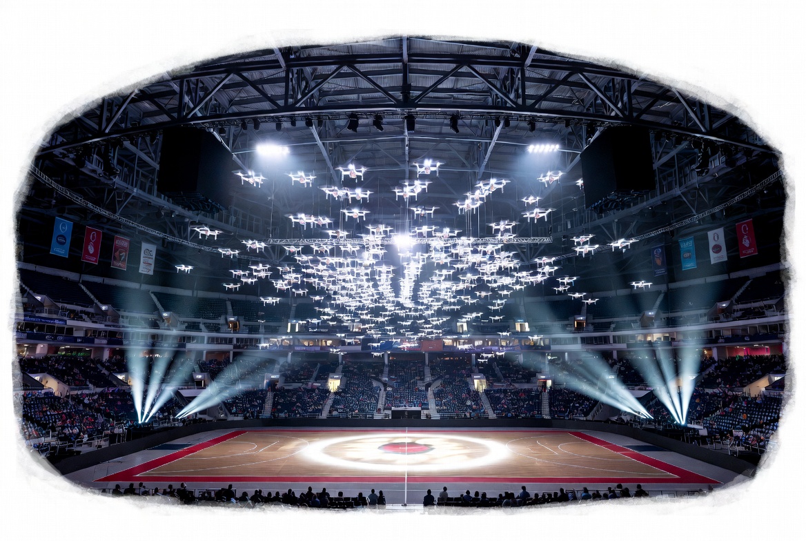 Indoor arena drone show insurance specialized event production coverage with drones flying inside a sports arena, audience seating, lighting, rigging, and venue safety controls